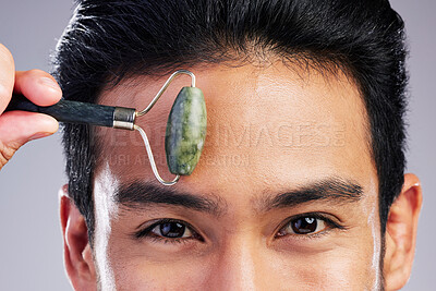 Buy stock photo Man, portrait or face massage with roller or quartz product for healthy skincare on studio background. Forehead, crystal stone treatment or male model with facial dermatology cosmetic for beauty glow