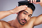 Portrait, beauty or man brushing hair in grooming with salon haircare product on studio background. Natural person, brush or confident healthy Asian male model with cool hairstyle in morning routine
