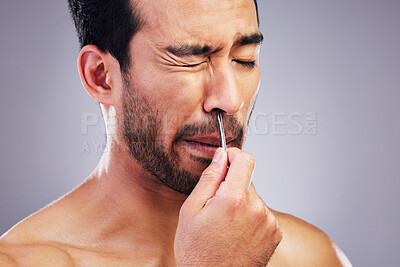 Buy stock photo Plucking hair, nose and a man with tweezers for grooming, hygiene and beauty on a studio background. Pain, face and an Asian person with tools for cosmetics or facial care isolated on a backdrop