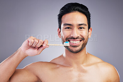 Buy stock photo Smile, portrait and a man brushing teeth on a studio background for cleaning, grooming and hygiene. Happy, wellness and an Asian person with a toothbrush for care of mouth isolated on a backdrop