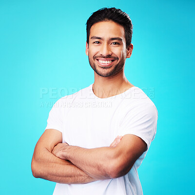 Buy stock photo Smile, happy and portrait of Asian man arms crossed with casual fashion isolated in a studio blue background. Relax, calm and young male person proud or confident mindset, natural and happiness