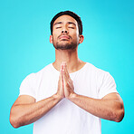 Meditation, worship or man in prayer with hands and belief or faith in God for spirituality, mindfulness and peace in studio. Christian, praying and person with religion and zen on blue background