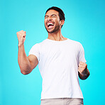 Happy asian man, winner and fist in studio for celebration, achievement and success on blue background. Excited model shout to celebrate winning prize, deal and victory of lottery, reward and bonus 