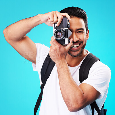 Buy stock photo Portrait, smile and man with a camera, photography and taking picture against a blue studio background. Face, male person or model with creativity, vintage technology or photographer with inspiration