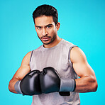 Portrait, man or fighter training, boxing or challenge against a blue studio background. Male person, healthy boxer or athlete with power, strong or serious face with workout goals, fight or wellness