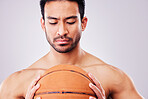 Fitness, basketball and a shirtless sports man in studio on a gray background for training or a game. Exercise, workout or mindset and a young male athlete holding a ball with focus or confidence