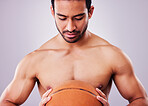 Exercise, basketball and a shirtless sports man in studio on a gray background for training or a game. Fitness, workout or mindset and a young male athlete holding a ball with focus or confidence