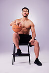 Portrait, fitness and basketball with a man on a chair in studio on a gray background for training or a game. Exercise, workout or mindset and confident young male sports athlete sitting with a ball