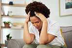 Stress, headache and woman on a sofa in the living room of her modern apartment with a burnout. Sick, migraine and exhausted young African female person relaxing on weekend in the lounge of her home.