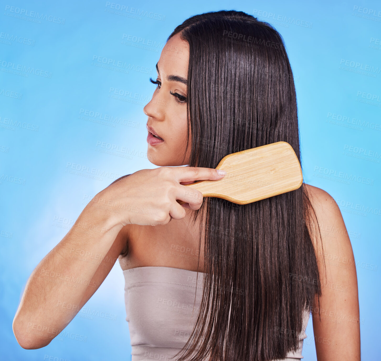 Buy stock photo Hair care, beauty and a woman with a brush in studio for self love, hygiene and shine. Salon, hairdresser and a female model person with shampoo, cosmetics and a hairbrush on a blue background