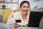 Happy woman, credit card and money with laptop on sofa for ecommerce payment, fintech password and online shopping. Female customer, computer and banking code for financial sales promotion at home 