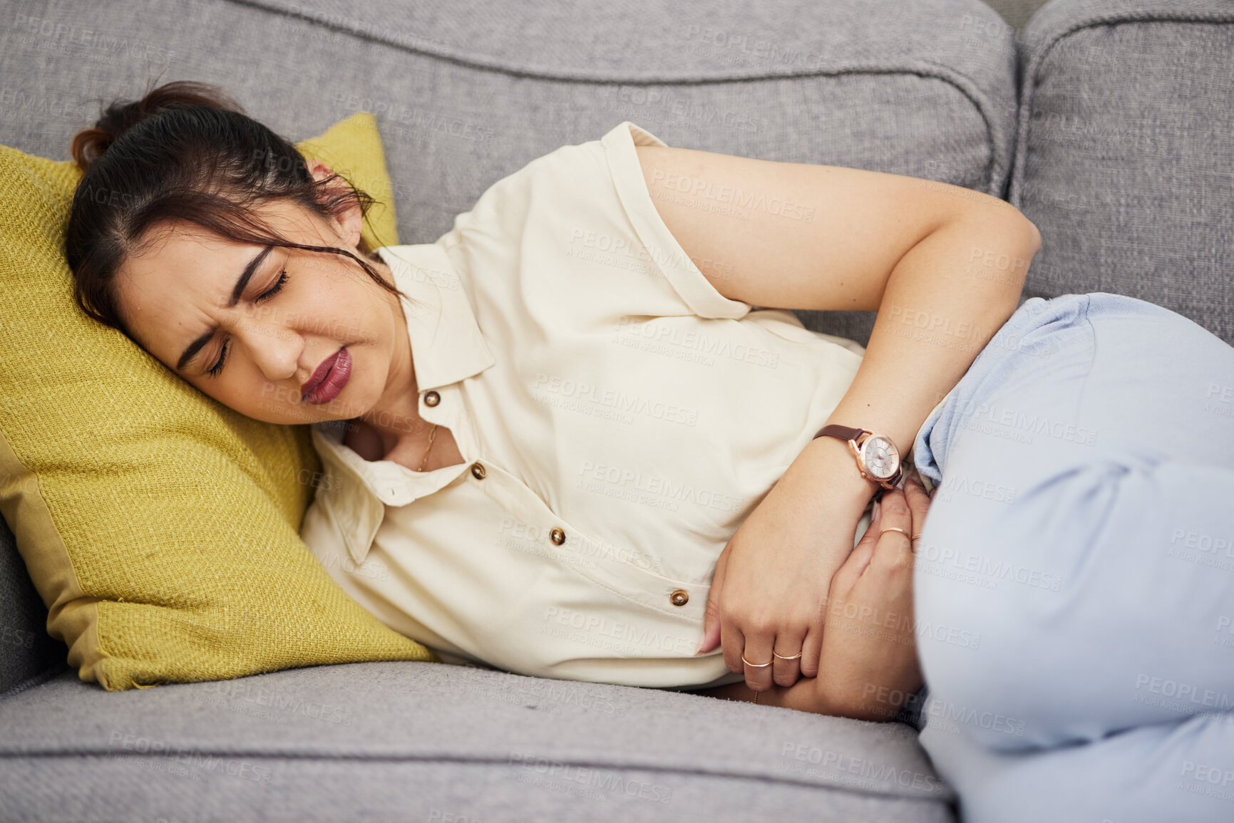 Buy stock photo Sick woman, stomach and pain in home for gastric health, digestion and colon emergency. Female person with stress, menstruation and abdomen risk of constipation, anxiety and endometriosis on sofa