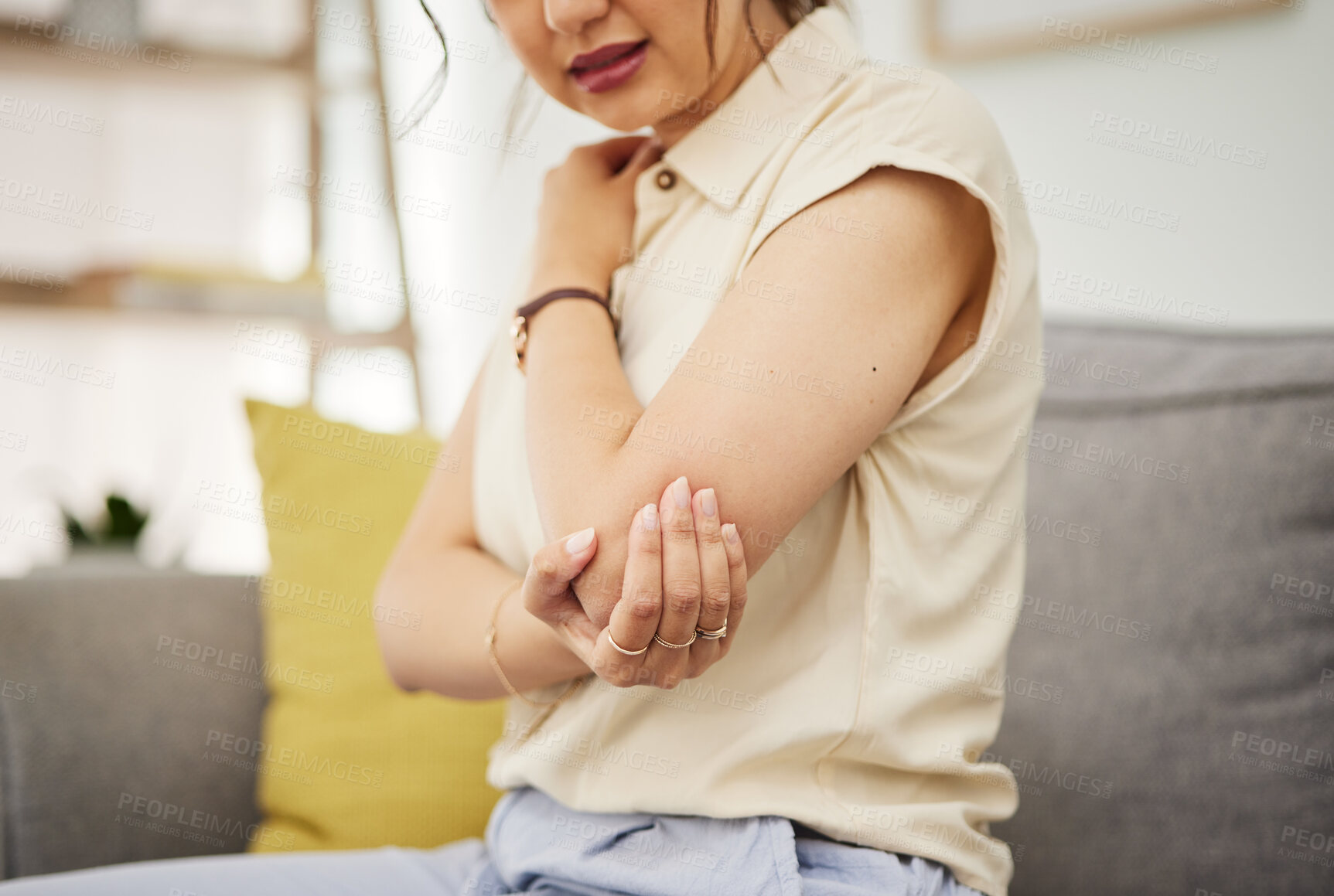 Buy stock photo Elbow, injury and hand of woman on a sofa with problem, arthritis or osteoporosis in her home. Arm, pain and female with joint, crisis or fibromyalgia in a living room with muscle tension or accident