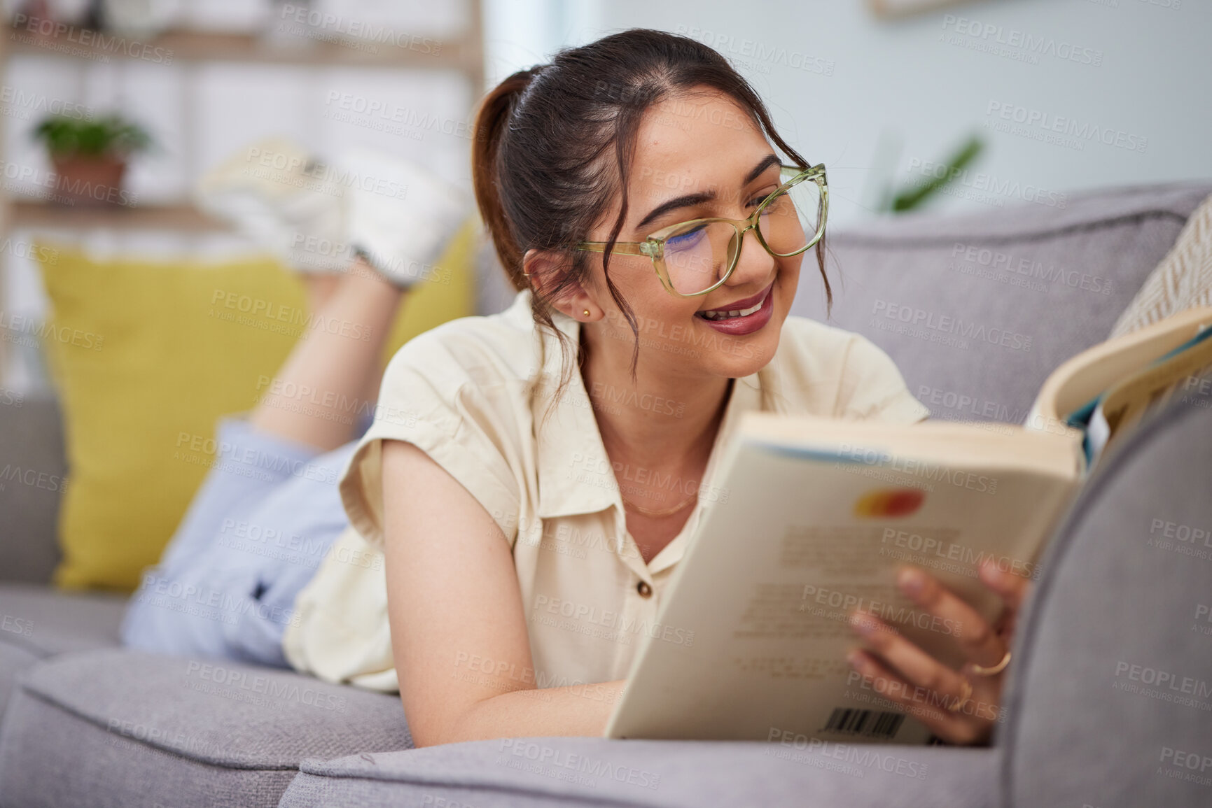 Buy stock photo Woman, sofa and reading book in living room for story, novel and learning knowledge. Happy female student, gen z girl and relax with books in lounge for studying, literature or hobby to enjoy at home