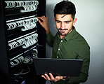 Laptop, data center and male technician in a server room for technical repairs by a control box. Technology, engineering and professional man electrician working on computer for cybersecurity system.