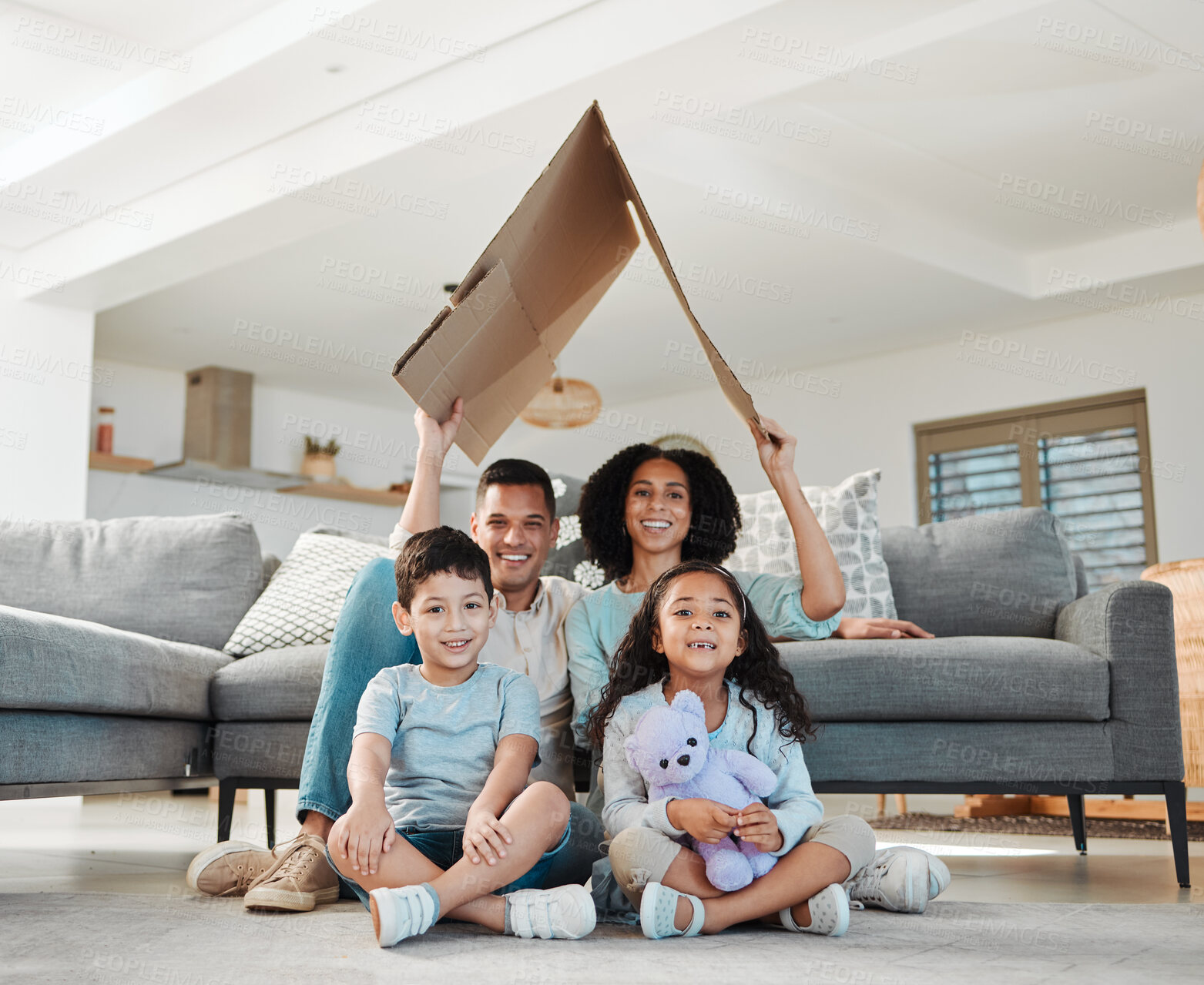 Buy stock photo Cardboard roof, portrait and a family in a lounge for security, safety and shelter as a family. Happy, house and a mother, father and children with refuge in a living room for insurance together