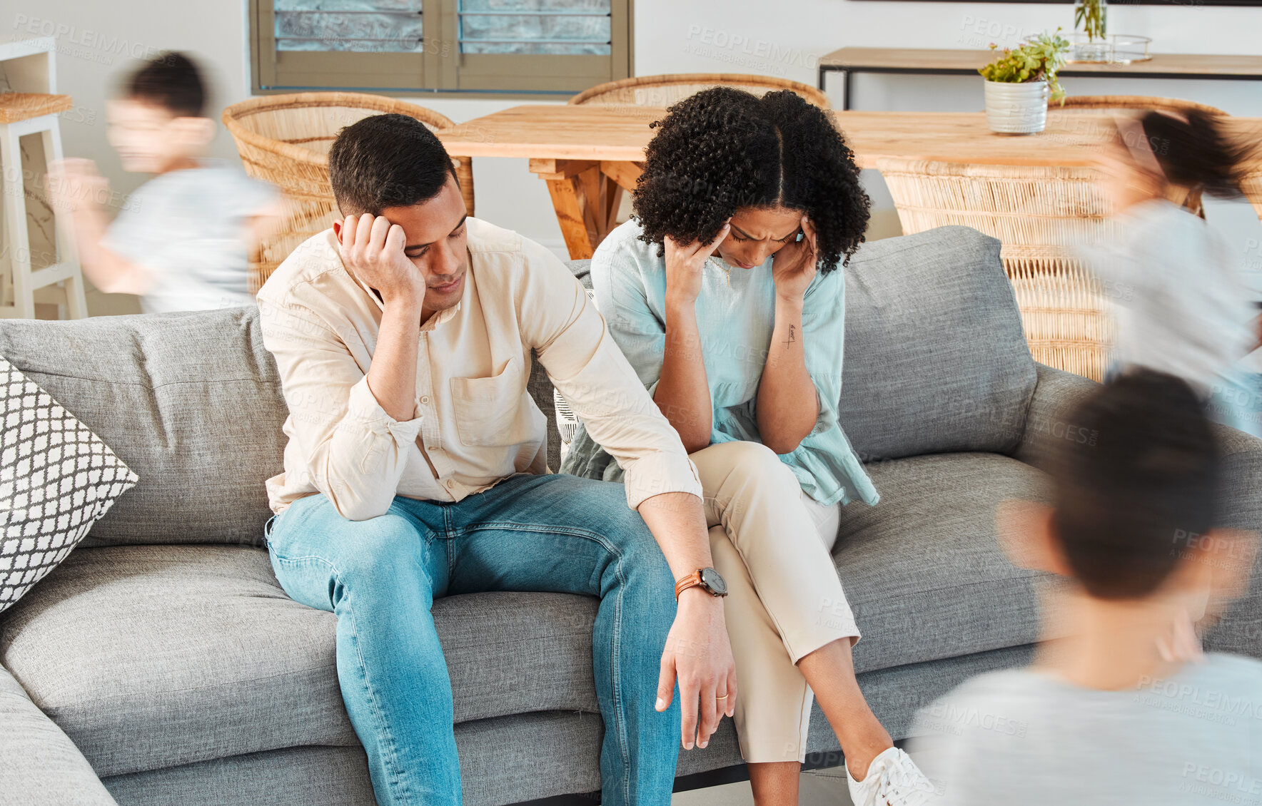 Buy stock photo Kids, running and tired parents on sofa with stress or chaos in living room, family home and children in house with energy. Exhausted, burnout and frustrated black couple on couch with young child