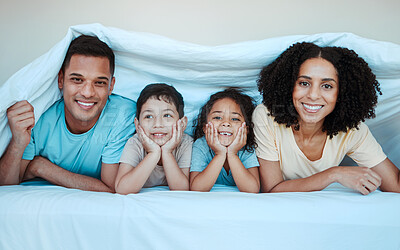 Buy stock photo Blanket, bed and portrait of parents with children for bonding, quality time and affection in morning. Love, family and happy mother, father and kids laying in bedroom for fun, playful and relaxing