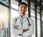 Crossed arms, confidence and portrait of a male doctor with a stethoscope in a medical hospital. Happy, smile and headshot of a professional young man healthcare worker or surgeon in medicare clinic.