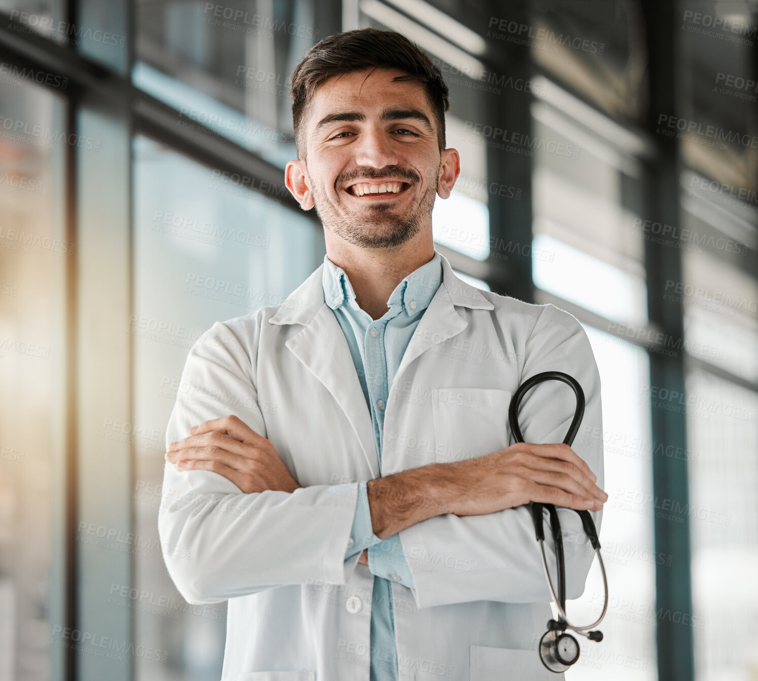 Buy stock photo Crossed arms, happy and portrait of a male doctor with a stethoscope in a medical hospital. Confidence, smile and professional young man healthcare worker or surgeon with pride in medicare clinic.