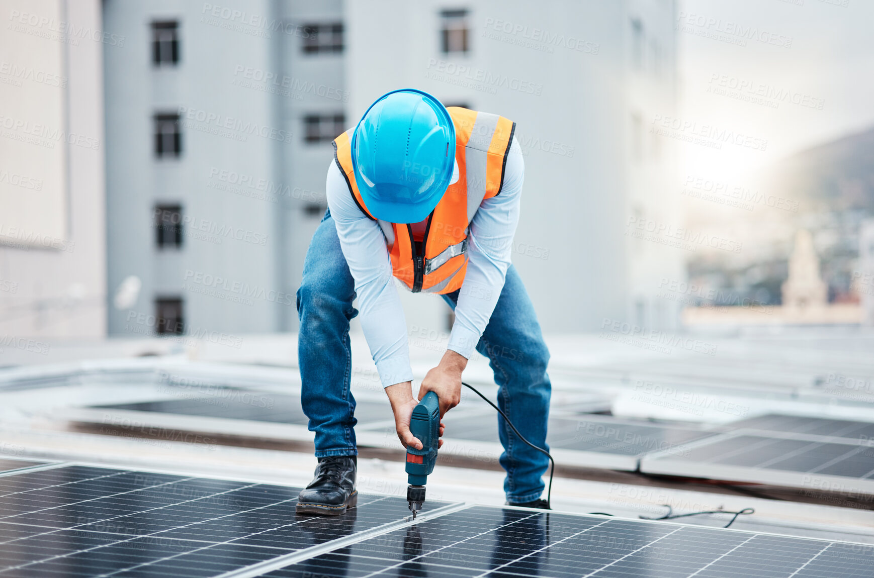 Buy stock photo Engineer man, drill and solar panel on roof with industry, sustainability or construction in city. Technician, power tools and photovoltaic system for building, development or renewable energy in cbd