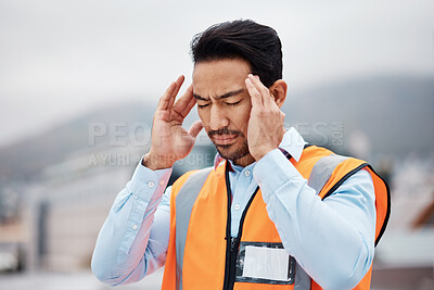 Buy stock photo Stress, headache and male construction worker on a rooftop of a building for inspection or maintenance. Migraine, burnout and young man engineering industry worker working in an urban town on site.