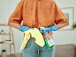 Back, woman and cleaning in home with bottle, cloth and disinfection of dirt, bacteria or dust. Closeup of hands of female person ready for housekeeping with chemical spray, detergent product or task