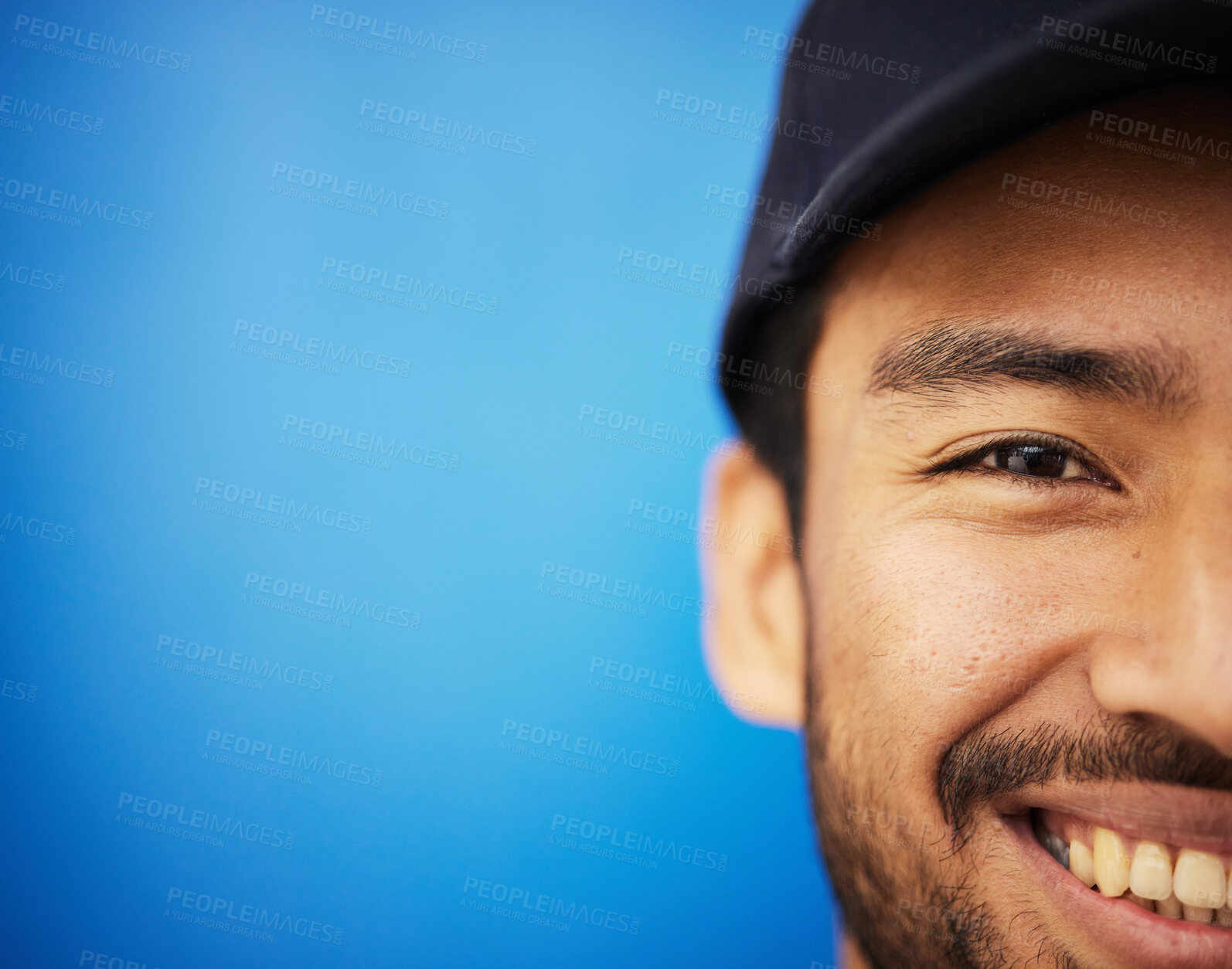 Buy stock photo Studio, portrait and closeup on half of man in sports on blue background with advertising, mockup or space with athlete. Happy, face and smile with cricket or baseball cap and fitness or wellness