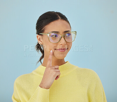 Buy stock photo Woman, smile and glasses in studio thinking, problem solving style and vision on blue background. Ideas, eyewear and happy model brainstorming with hand on face in cool fashion, mindfulness and gen z