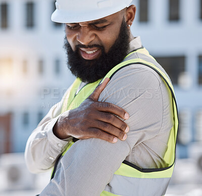 Buy stock photo Injury, arm pain and a black man construction worker on a building site, feeling fatigue in his shoulder. Burnout, emergency or accident and a male engineer holding his muscle with inflammation