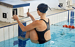 Swimming, sports and woman start in pool for exercise, training and workout for competition in gym. Fitness, diving and female swimmer holding block for water sport race, challenge and performance