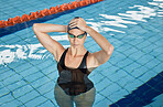 Athlete, swimming pool and ready with cap, goggles and swimwear for competition training, fitness and summer exercise. Serious, wellness and swimmer woman with water sports gear for workout challenge