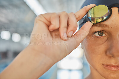 Buy stock photo Sports, eye and goggles with a woman swimmer getting ready for an event, race or competition in a gym. Fitness, exercise and workout with the face a young athlete training at a swimming pool closeup