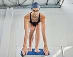 Swimming, sports and woman jump in pool for exercise, training and workout for competition in gym. Fitness, diving and female swimmer on podium block for water sport race, challenge and performance