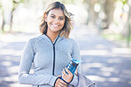 Nature, fitness and portrait of a woman with a water bottle for an outdoor workout or training. Sports, happy and young female athlete with a smile in a park for a running cardio exercise in a garden