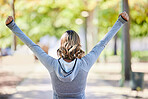 Fitness, exercise and a woman outdoor with hands raised at a park for celebration, win and success. Back of young female person on a road in nature excited about workout, running or training goals