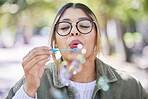 Face of woman blowing bubbles in park, garden and freedom for fun, good mood and carefree personality. Happy, young and female gen z girl with soap bubble wand outdoor to relax on summer holiday 