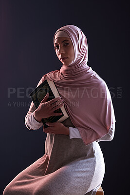 Buy stock photo Quran, religion and portrait of a muslim woman in a studio with traditional clothes and hijab. Serious, faith and young islamic female person with the holy Arabic book isolated by a black background.