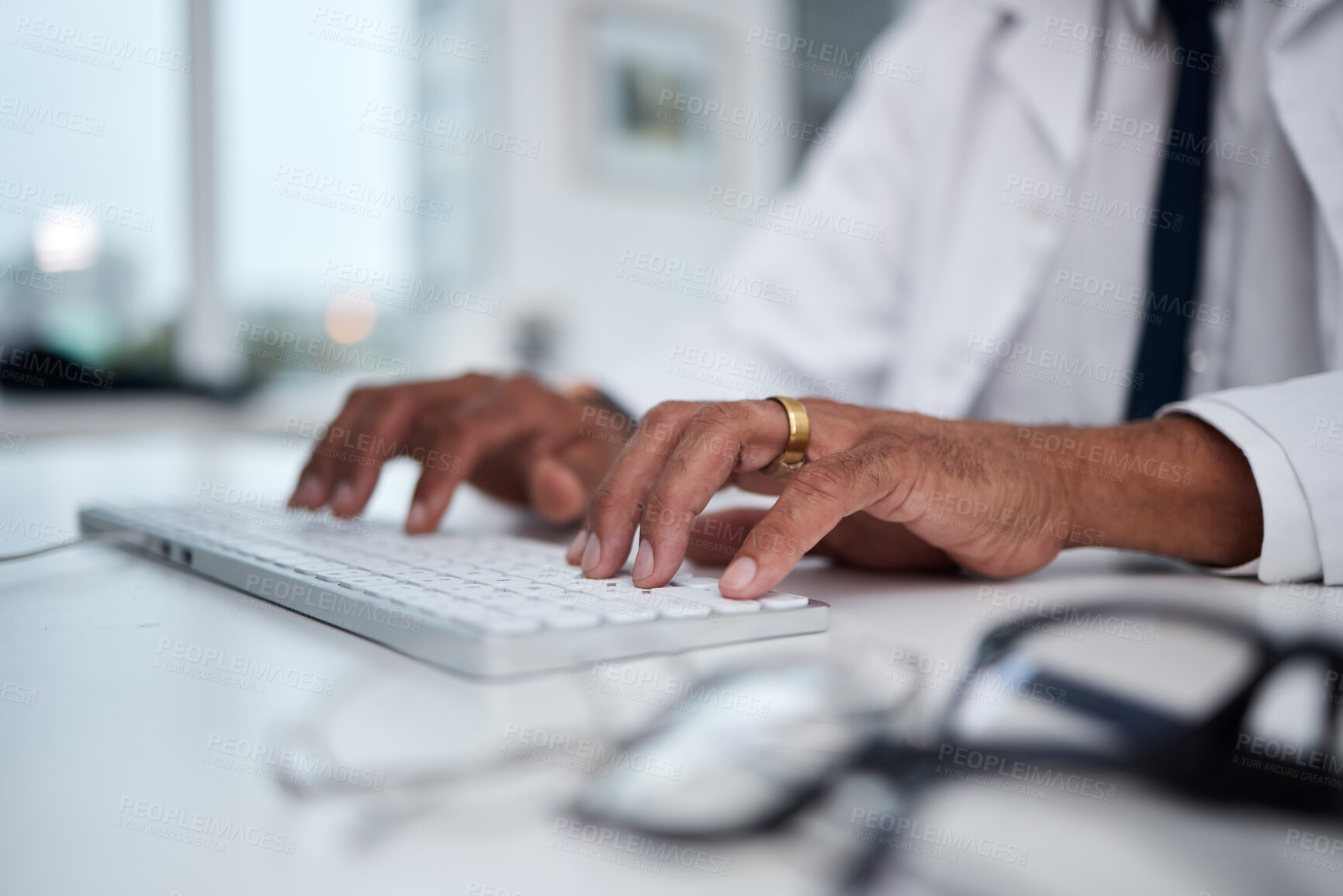 Buy stock photo Hands, keyboard and doctor typing at desk for research, healthcare and telehealth on internet in hospital. Computer, fingers and medical professional writing email, planning and work online in clinic