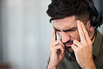 Telemarketing, call center and man with a headache, burnout and tech support with stress, pain and overtime. Male person, employee or consultant with a migraine, health problem and agent with tension