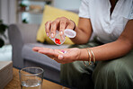 Woman, hands and pills on sofa for medication, healthcare or cure for illness, virus or flu at home. Closeup of female person taking pharmaceutical drugs or capsules for sick, fever or mental health