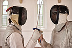 Fencing, sword and people start fight in sports training, exercise or challenge in hall. Martial arts, combat and athlete fencers with mask and costume for fitness, competition or target in swordplay