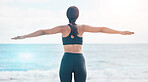Fitness, freedom and woman back at the beach stretching arms after running or cardio routine in nature. Exercise, rear view and female at the ocean with body stretch for training success or milestone