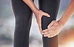 Closeup of sports person, knee pain and injury for fitness, first aid emergency and exercise health risk outdoor. Legs of athlete, accident and workout mistake with injured muscle, zoom and wound