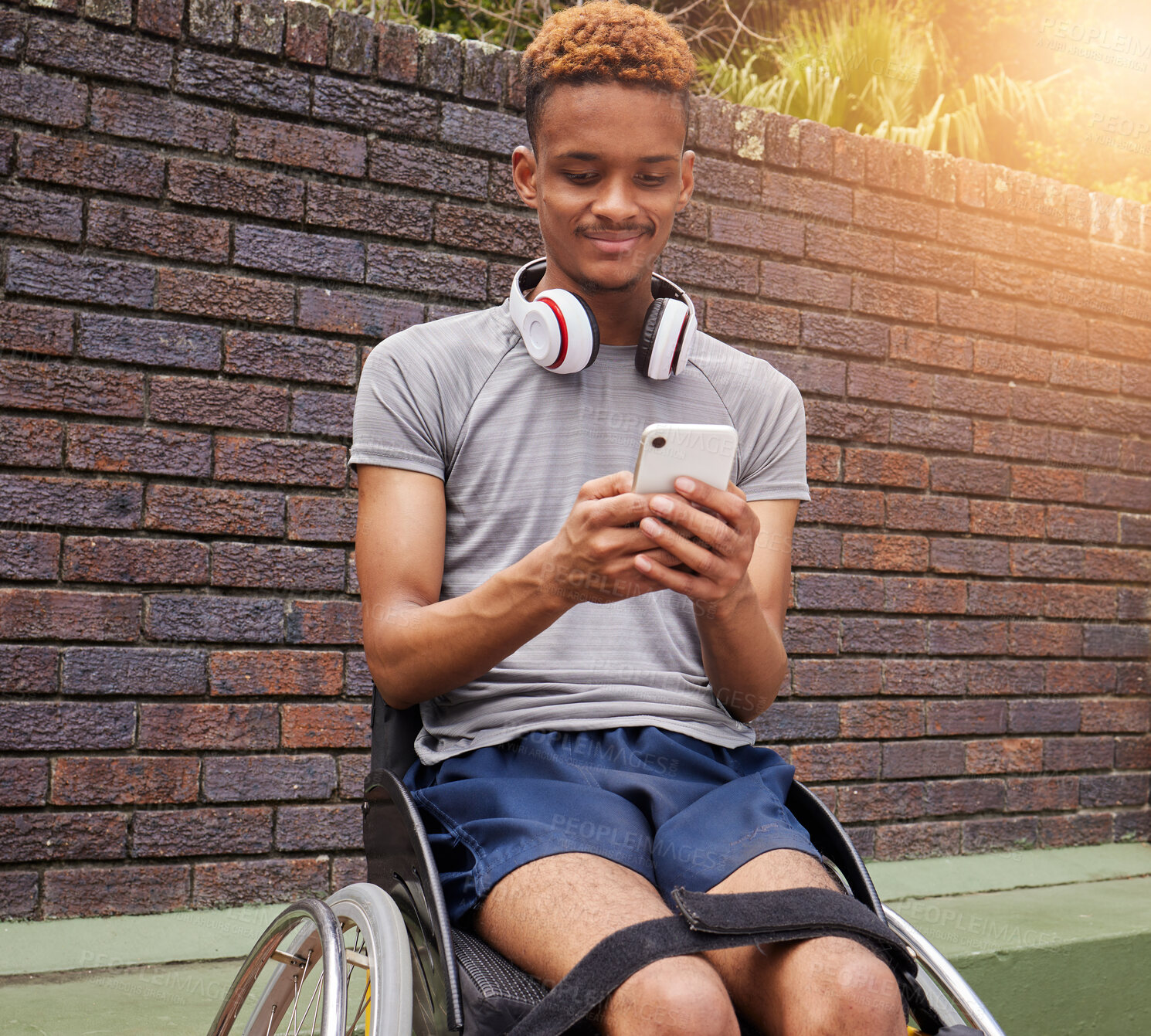 Buy stock photo Phone, wheelchair and outdoor man with disability typing internet, web or online search for fitness training information. Cellphone communication, reading and African person post to social media app