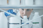 Scientist woman, shelf and bottle in lab with choice, thinking or idea for experiment, innovation or pharma career. Science lady, medical expert and pharmaceutical employee in laboratory for decision