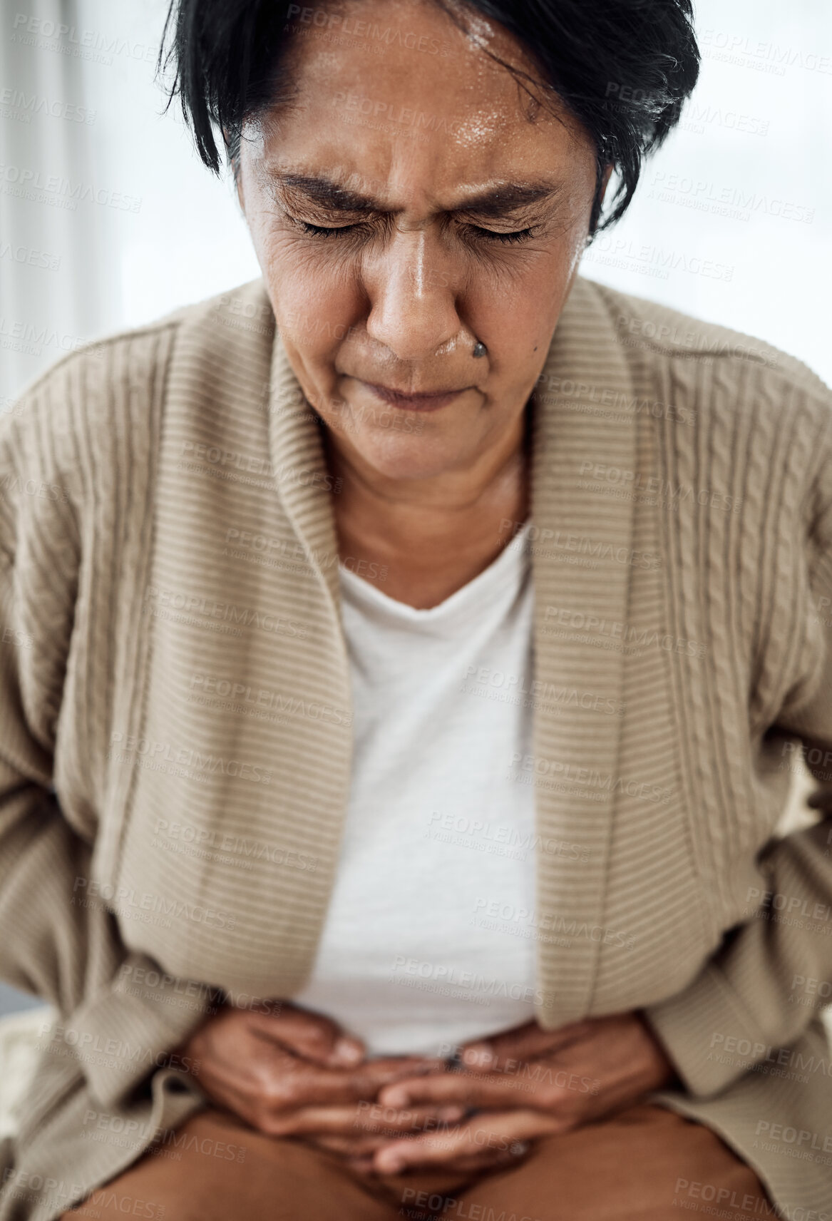 Buy stock photo Stomach pain, sick or illness with a senior woman in her home, holding her belly in discomfort. Healthcare, medical and emergency with an elderly pensioner feeling uncomfortable after food poisoning