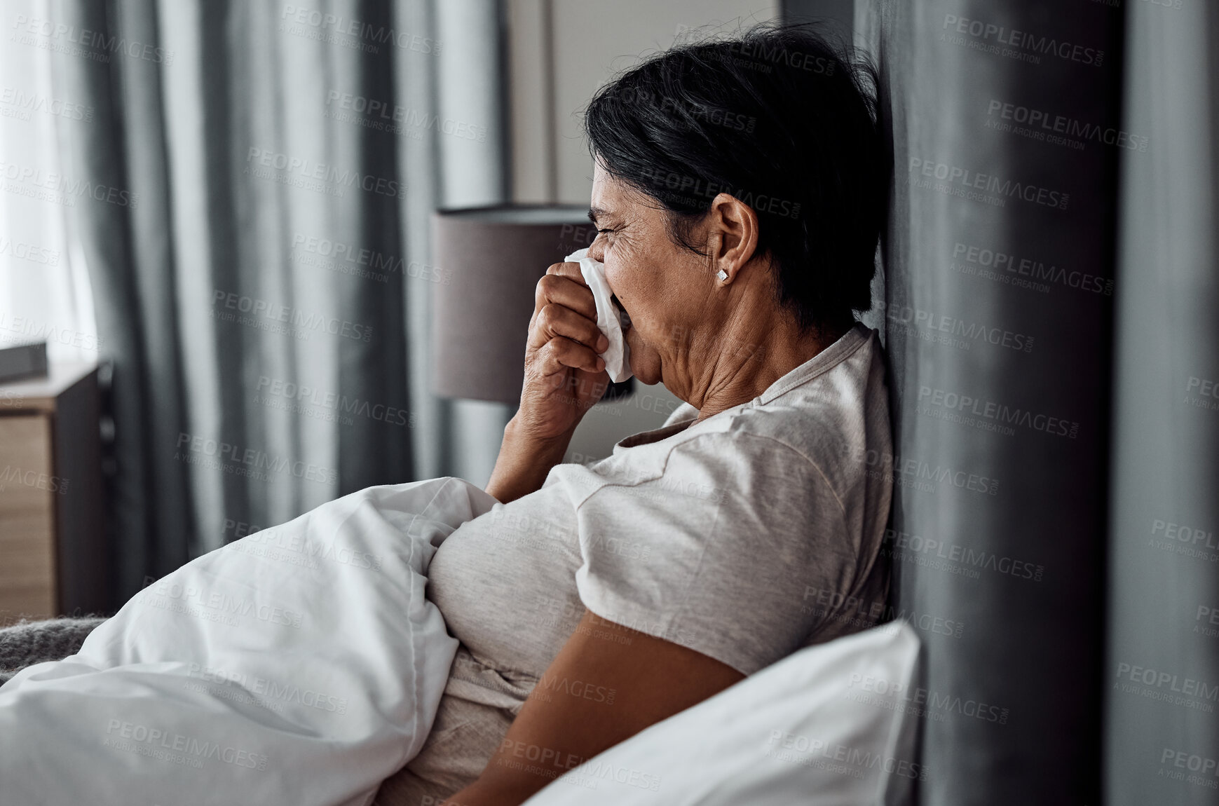 Buy stock photo Sick, tissue and elderly woman in bed blowing nose, flu or viral infection in her home. Allergies, bacteria and senior female sneezing, coughing or sore throat in a bedroom with virus or covid