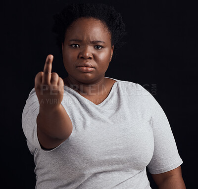 Buy stock photo Portrait, anger and black woman with middle finger, opinion and angry expression on a dark studio background. Face, female person and African model with hate sign, rude and frustrated with conflict