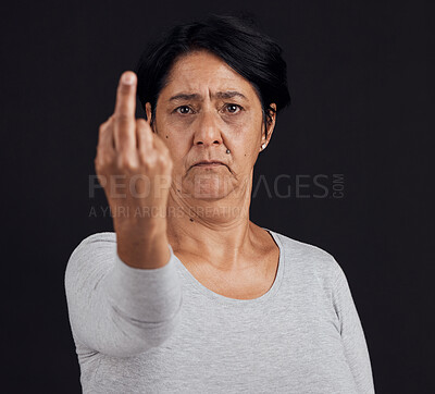 Buy stock photo Portrait, reject and senior woman with middle finger, opinion and angry expression on a black studio background. Face, female person or elderly model with hand gesture, rude and frustrated with anger